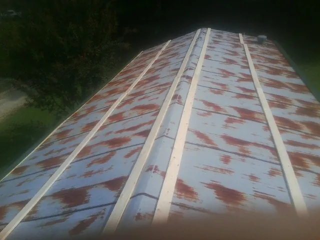 Rusted metal roof panels with new wood purlins before replacement — Storm Damage Roof Repair in Hughesville by Roofing Brothers