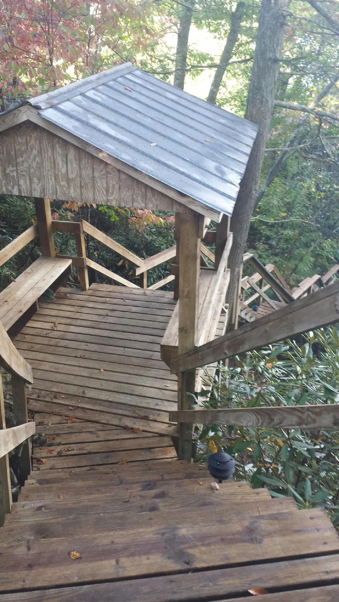 Metal roofed shelter over wooden steps on a wooded walkway — Skylight Repair & Installation work by our crew in Hughesville