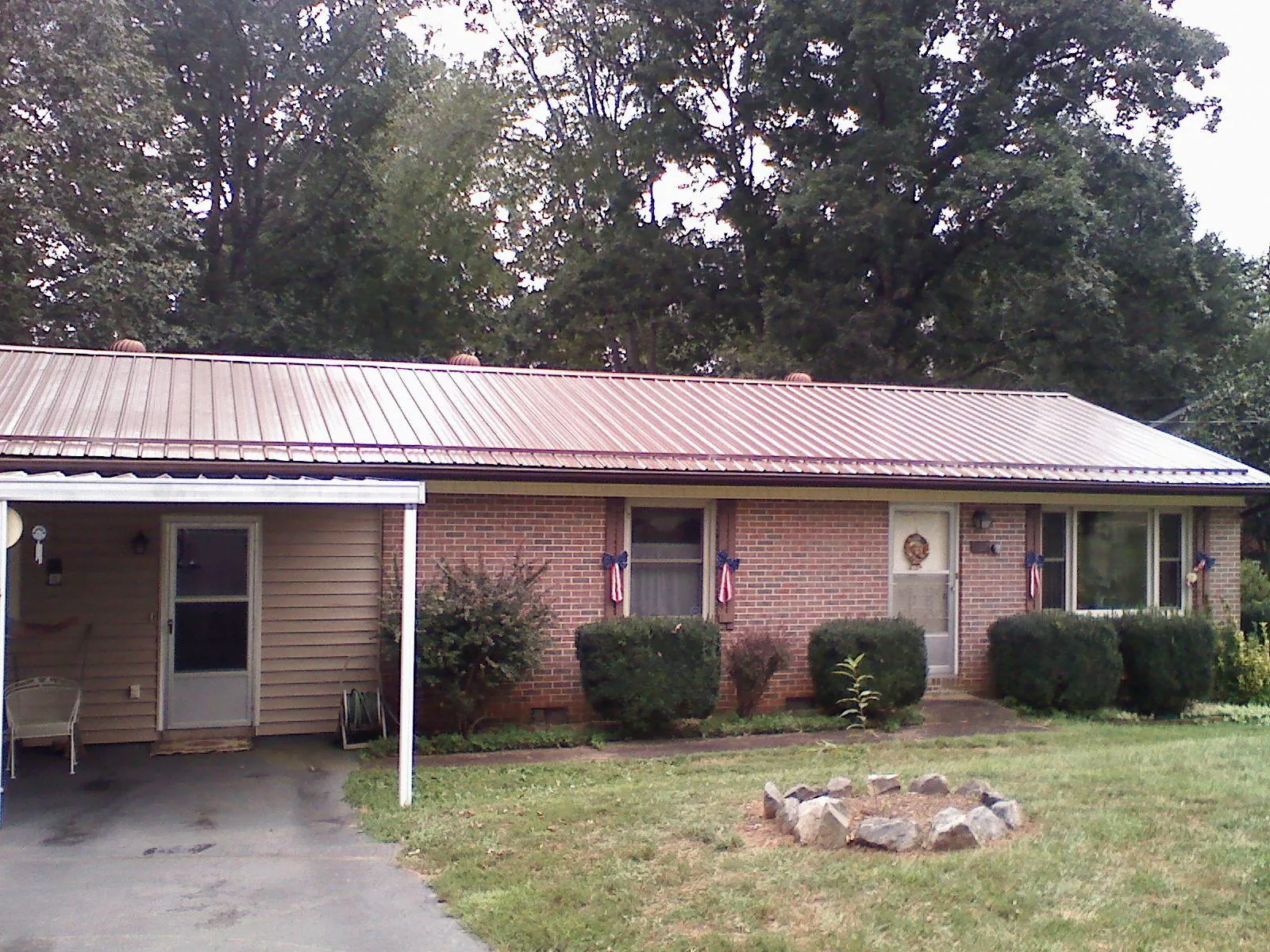 Bronze metal roof and carport on a brick ranch home — Roof Repair work by our crew in Hughesville